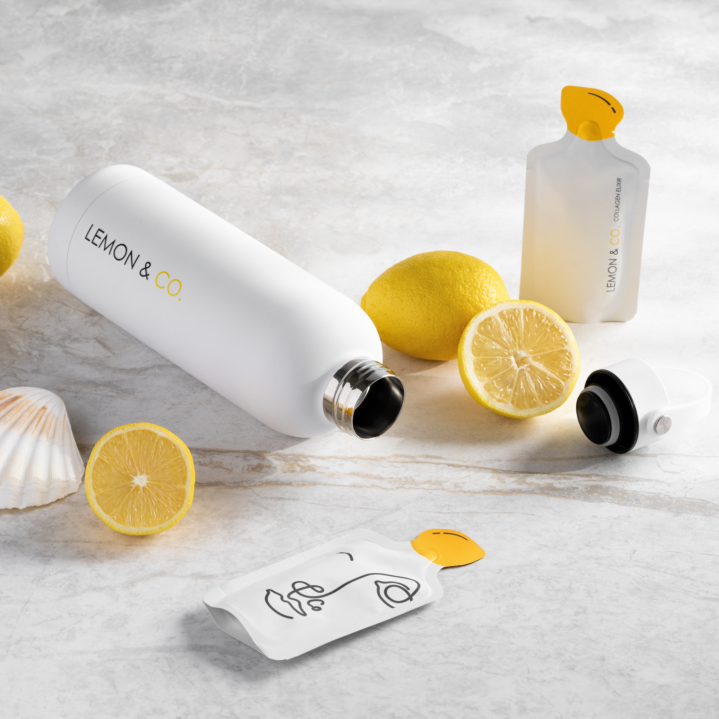 Lemon & Co. Bottle lying on its side with Liquid Collagen Elixir sachets and fresh lemons